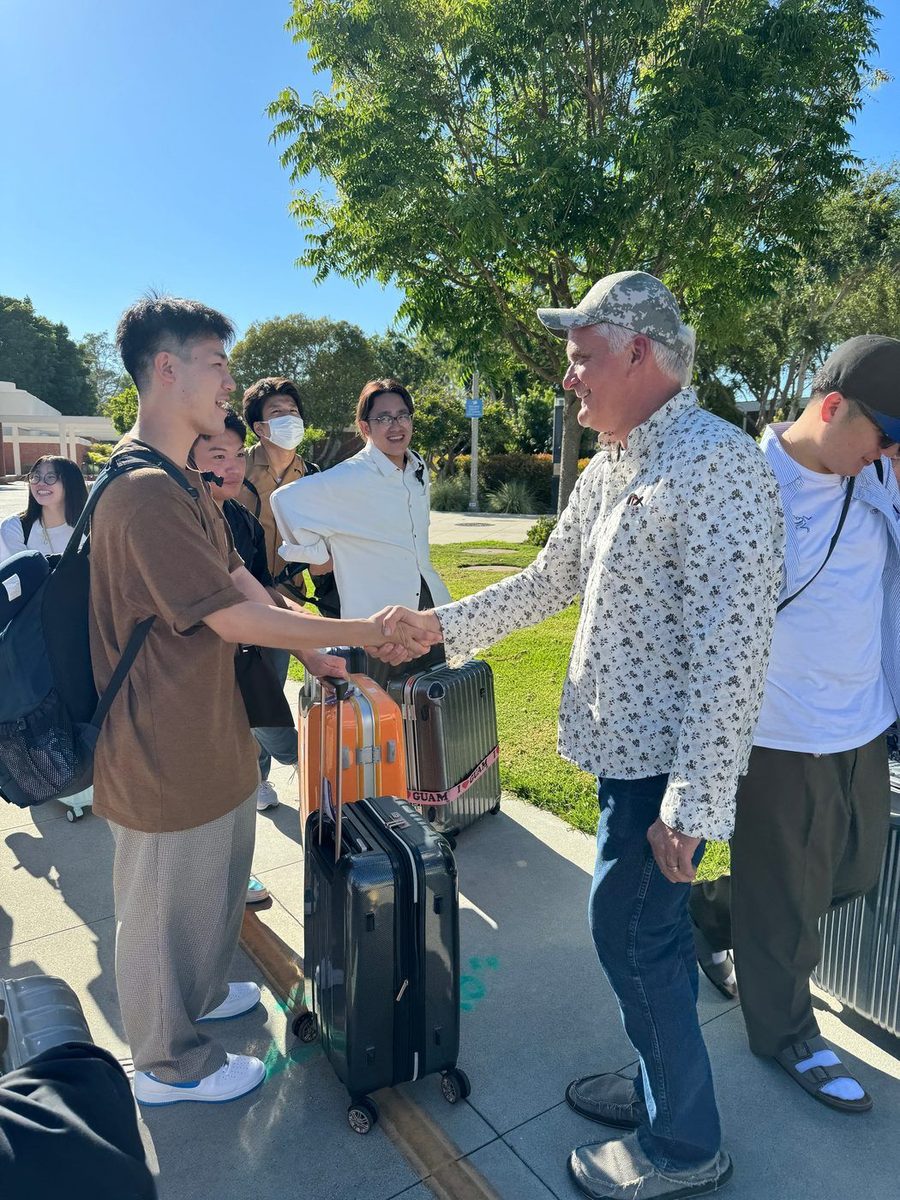 Host greeting international student on arrival day with handshake